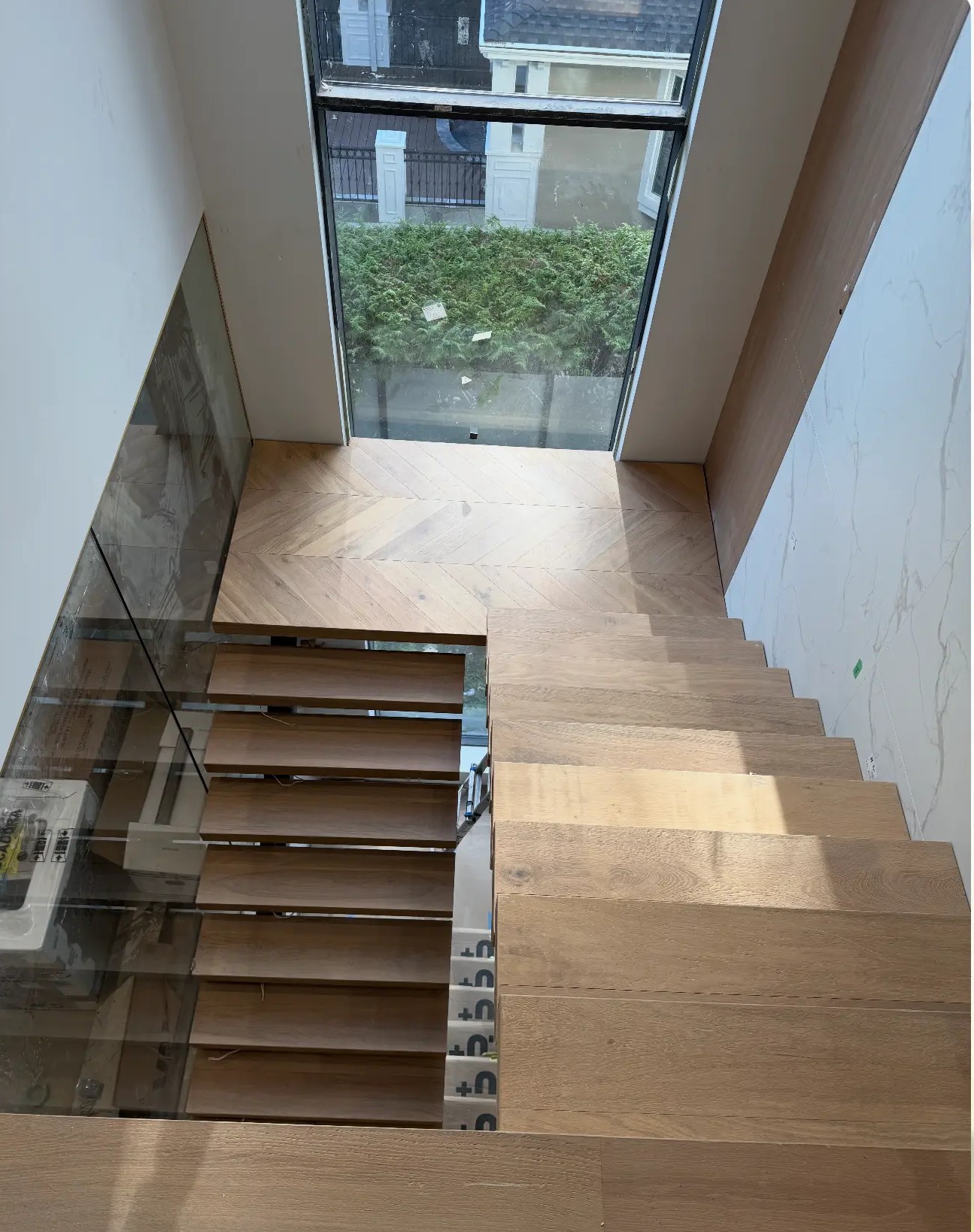 Floating oak stair treads with fishbone landing in Vancouver